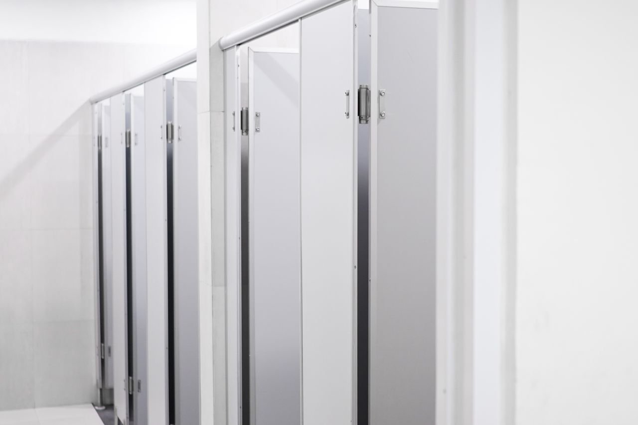 Clean and sleek public washroom with modern laminate partition cubicles.